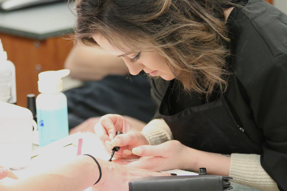 female student working on a manicure