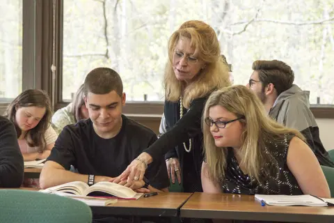 Jump start instructor assisting two students in a classroom setting.