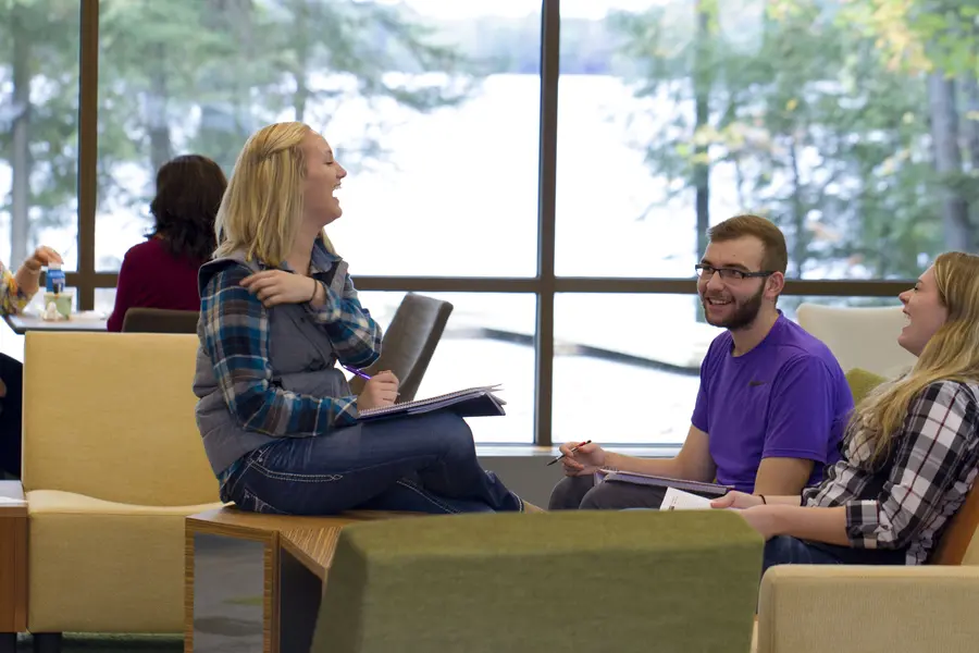 Group of students chatting and laughing in student lounge at Lakeside Commons.