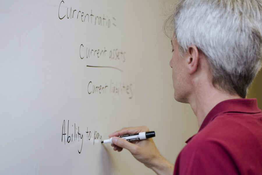 Male instructor writing on white board