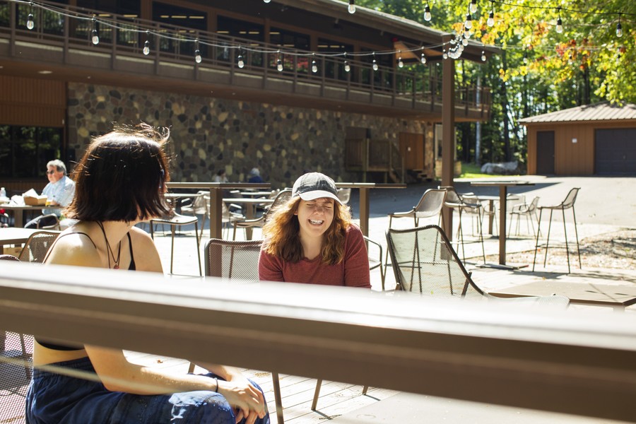 female students laughing outside on patio