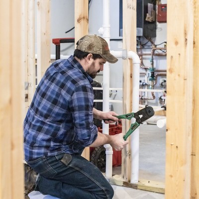 male plumbing apprentice clamping a pipe