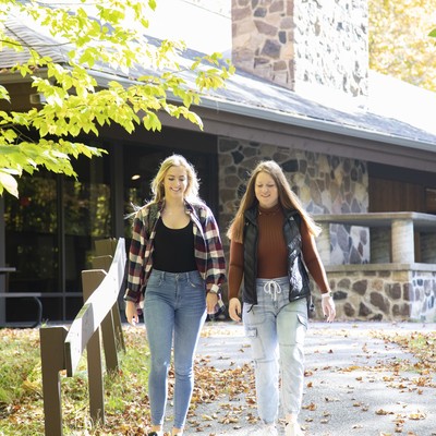 two females walking on the path by building in spring