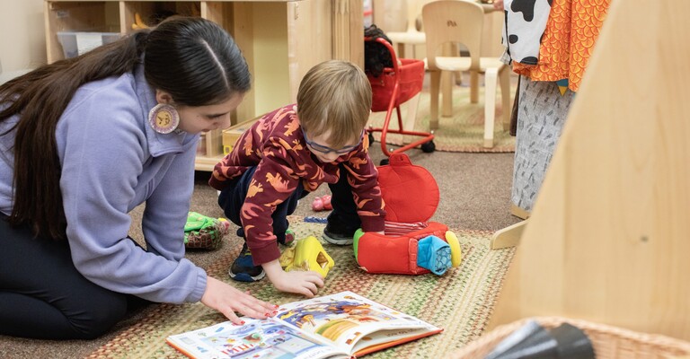 early childhood student reading with a preschool boy