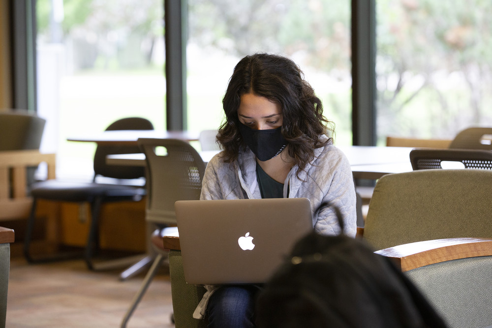 female student with face mask in student lounge