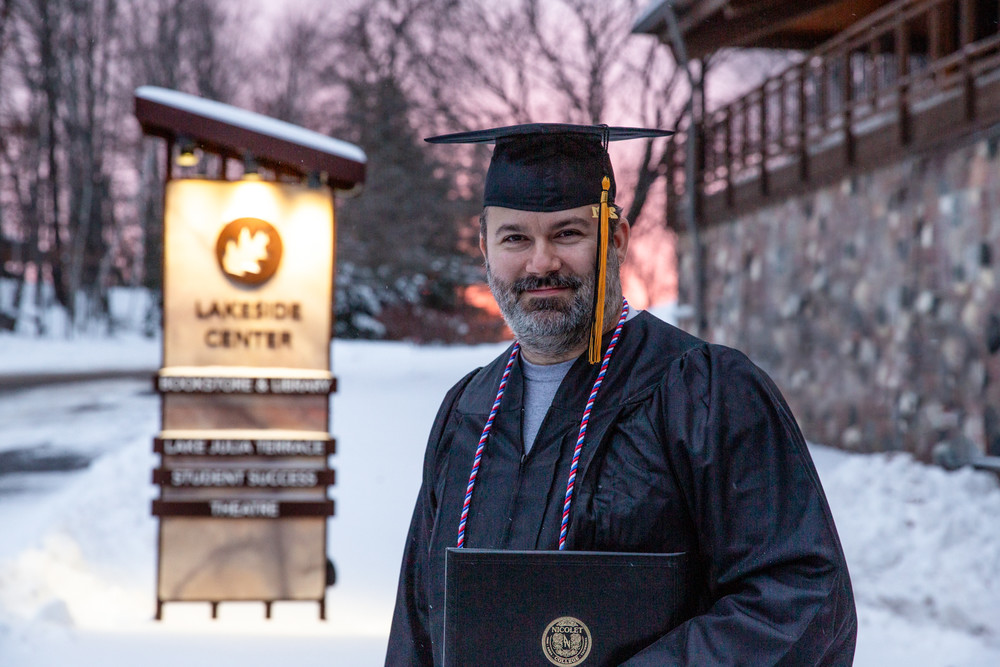 male adult graduate standing outside the lakeside center