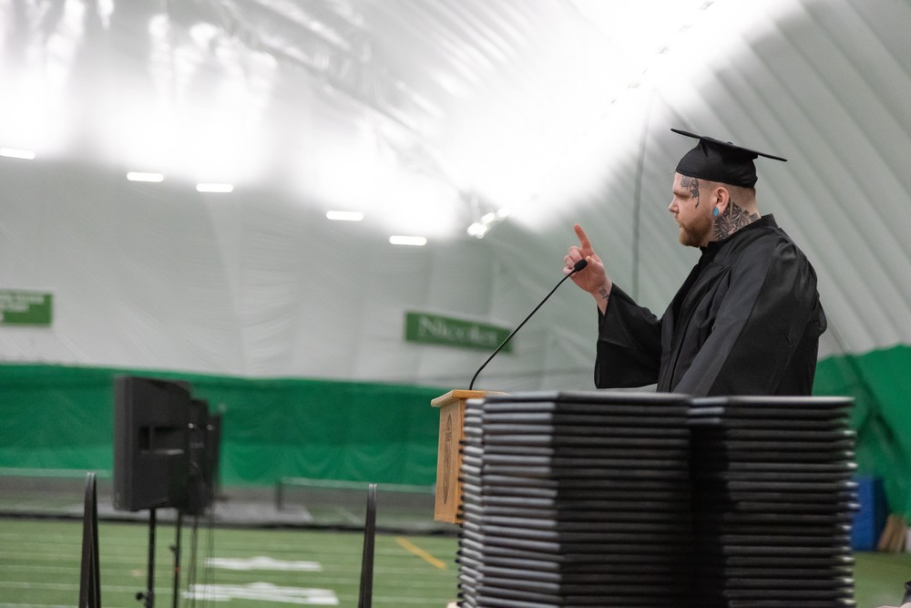 Josh Newman giving commencement speech on stage at graduation