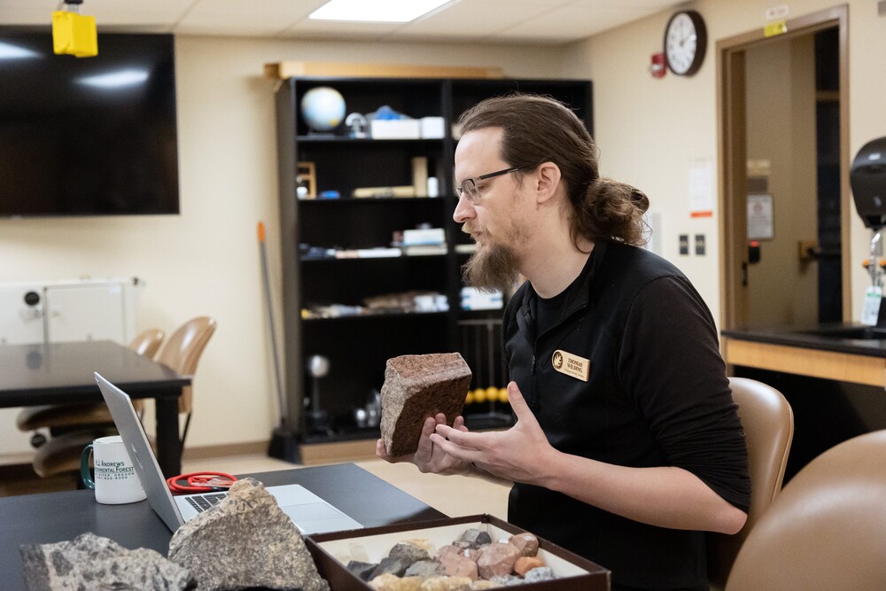 instructor sitting in a classroom teach geology to online class