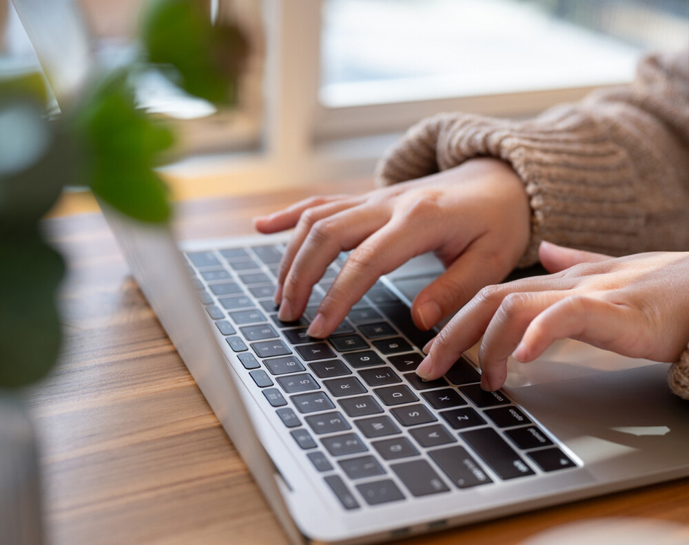 Hands typing on a laptop keyboard