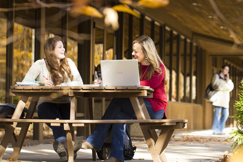 Female students laughing at table