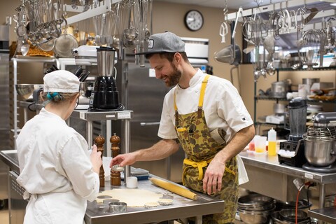 instructor chef mitch working in the kitchen with a student