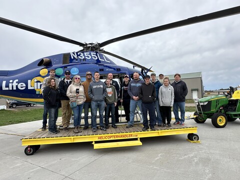 class standing in front of helicopter