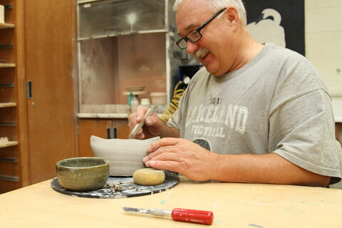 An older learner in a Nicolet College pottery class.