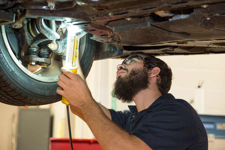 automotive student looking under car