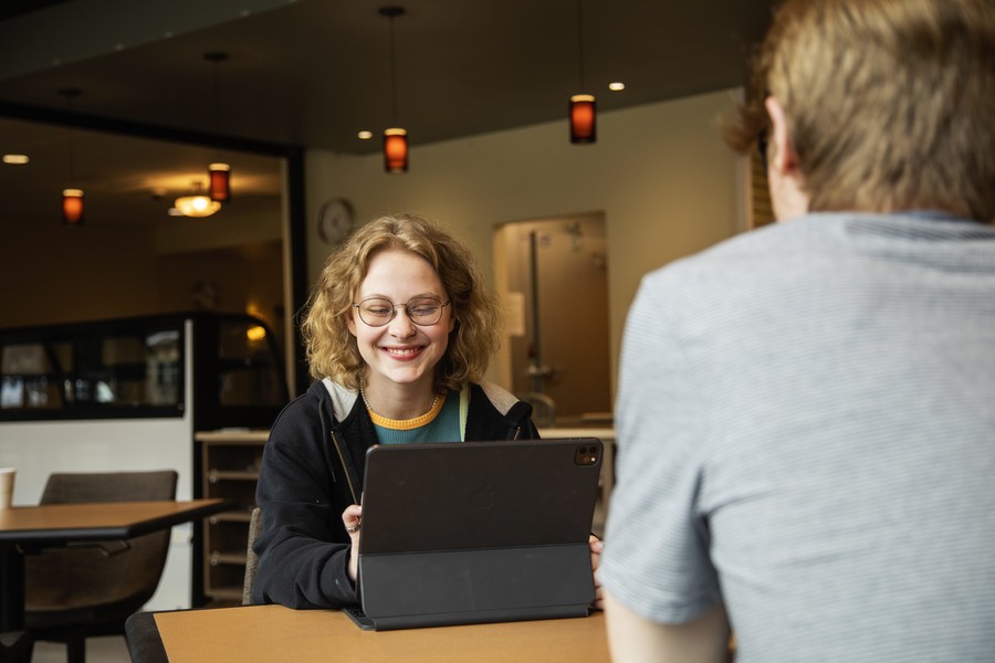 female student with laptop, laughing 