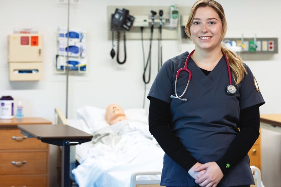 A smiling nursing student in a classroom.